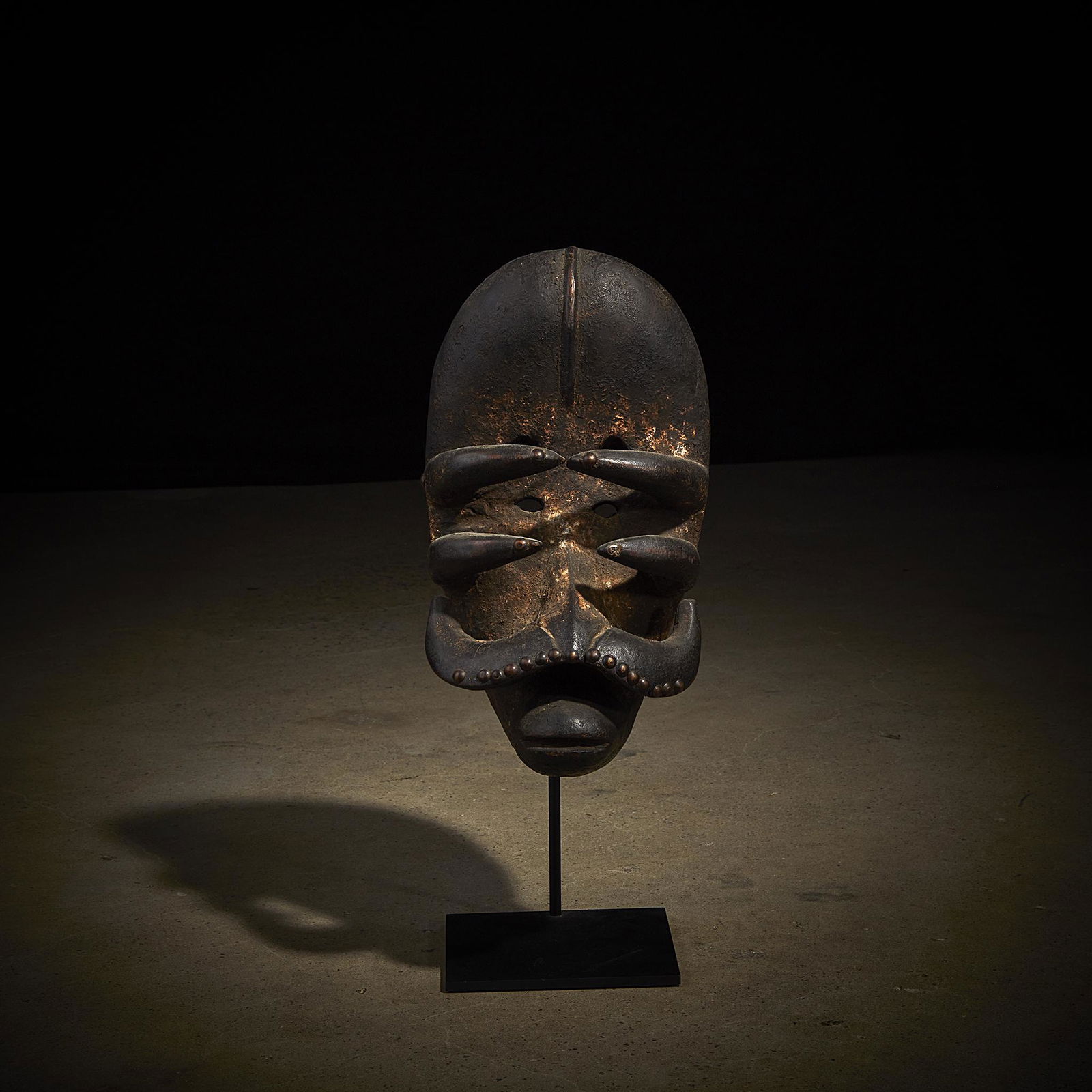 A Bete mask, Cote d'Ivoire: A Bete mask Cote d'Ivoire Carved wood, of powerful construction and exhibiting a combination of anthropomorphic and zoomorphic features, with a bulbous forehead above a series of six raised tusk-like