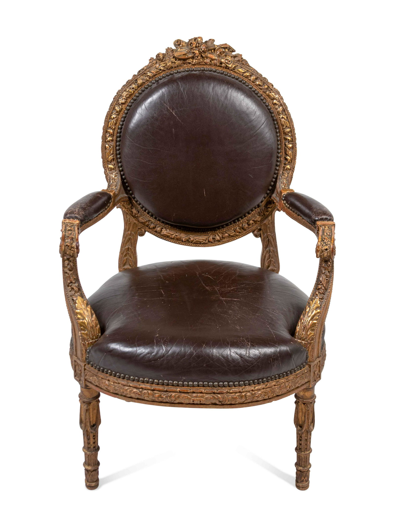 A Louis XVI Style Leather Upholstered and Parcel Gilt: A Louis XVI Style Leather Upholstered and Parcel Gilt Fauteuil Height 40 x width 26 x depth 25 inches. Property from the Estate of Sally Gatling Tomlinson, Atlanta, Georgia