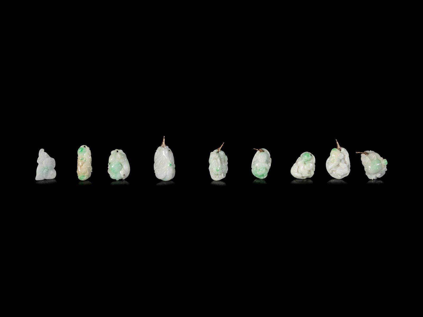 Fourteen Chinese Jadeite Pendants: Fourteen Chinese Jadeite Pendants comprising twelve fruit and flower shaped pendants, and two bi-disk form pendants. Diameter of largest 1 1/2 in., 3.8 cm.