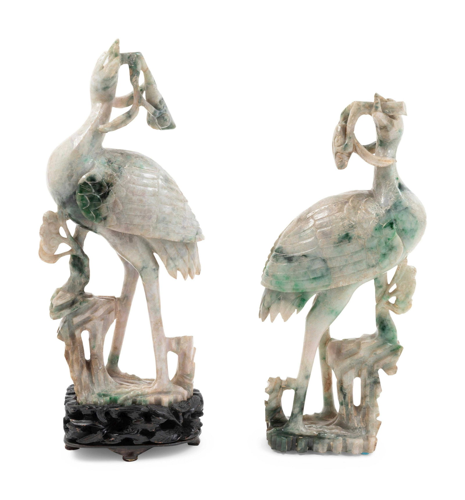 A Pair of Chinese Apple Green and White Jadeite Figures: A Pair of Chinese Apple Green and White Jadeite Figures of Cranes each stand next to the rockery with a fish in its mouth. Height 9 1/2 in., 24 cm. Property from the Estate of Daniel A. Wein, Denver, 