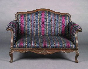 A Pair of Upholstered Walnut Settees, Height 36 x: A Pair of Upholstered Walnut Settees, the carved crest over an upholstered back, seat, and armrests, with foliate scroll motif carving on the armrests and apron, raised on cabriole legs ending in scro