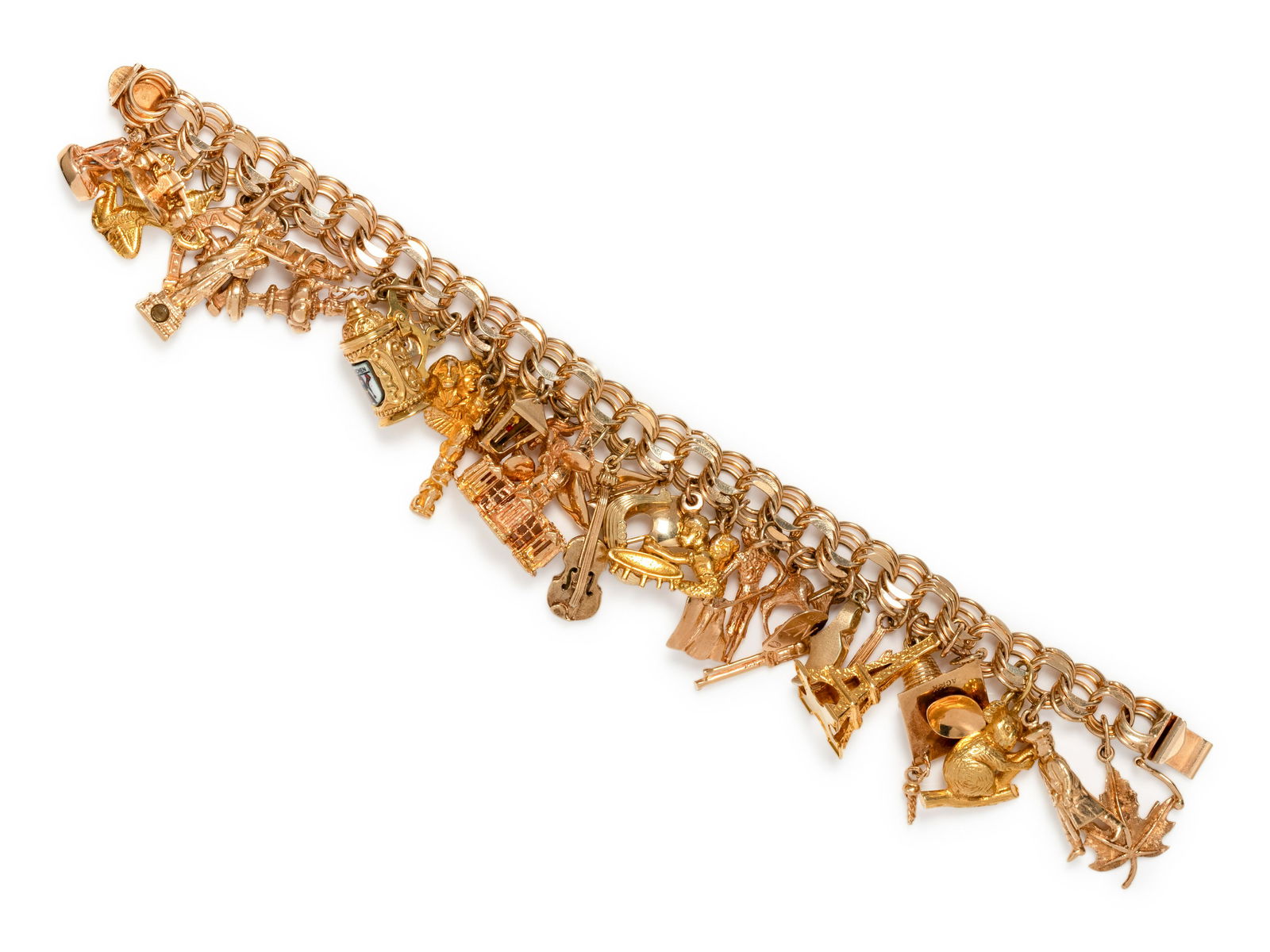 YELLOW GOLD CHARM BRACELET: YELLOW GOLD CHARM BRACELET Consisting of a fancy link bracelet suspending a Danish Little Mermaid charm, a telephone charm, a gold-plated figure charm, a Pennsylvania Dutch horseshoe and figure charm,