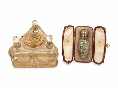 A Group of Metal-Mounted Glass Scent Bottles: A Group of Metal-Mounted Glass Scent Bottles Late 19th/Early 20th Century comprising an English scent flask with a retail case for Hunt & Roskell and a continental three-bottle perfume caddy. Height o