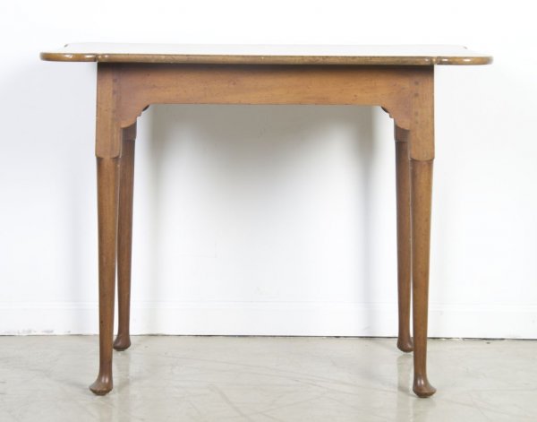An American Queen Anne Style Table, Kittinger, Heigh: An American Queen Anne Style Table, Kittinger, the rectangular top with rounded corners raised on tapering legs ending in pad feet. Height 26 1/4 x width 33 3/4 x depth 21 3/4 inches.