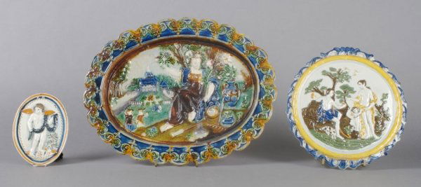 A Collection of Three Earthenware Relief Plaques,: A Collection of Three Earthenware Relief Plaques, of various forms and makers, each depicting a figural scene. Width of widest 11 7/8 inches.