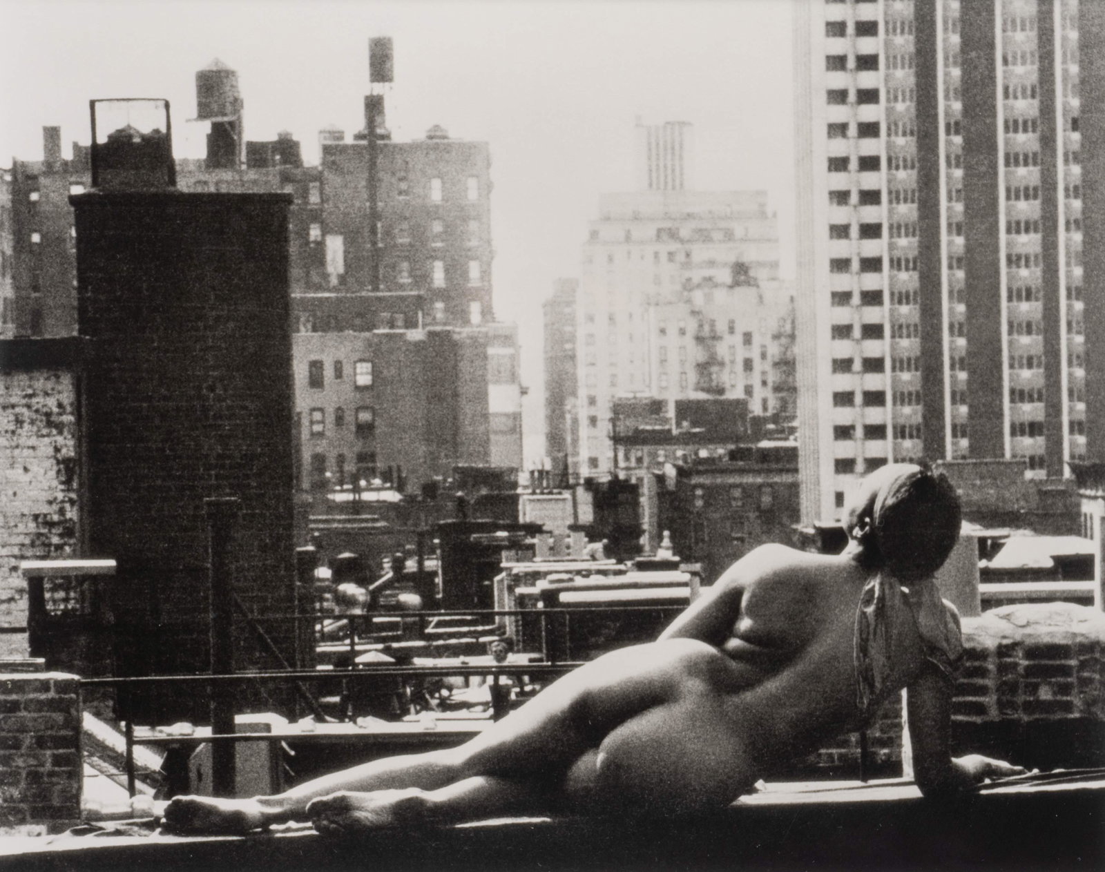 Artist Unknown Reclining Nude on New York Rooftop: Artist Unknown Reclining Nude on New York Rooftop gelatin print signed illegibly (Ticlluha ?)on reverse, numbered 29/250 and dated 1999. Image 7 1/4 x 9 inches.