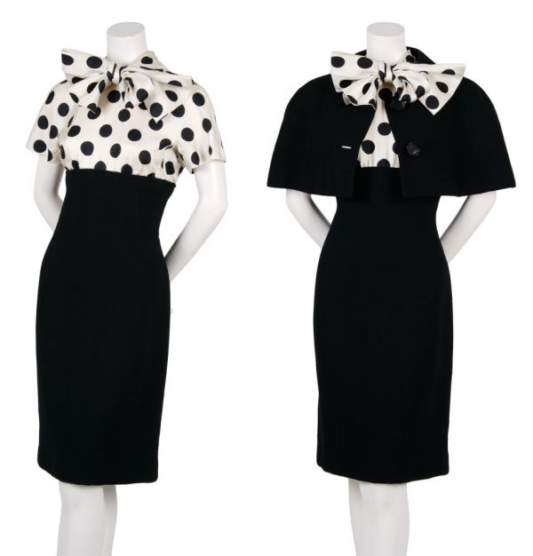 A Norman Norell Black Crepe Ensemble,: A Norman Norell Black Crepe Ensemble, 1960s, dress with cap sleeves, polka dot silk faille bodice with scarf bow, capelet with notched collar, fully lined. Labeled: Norman Norell/New York/Henri Bendel