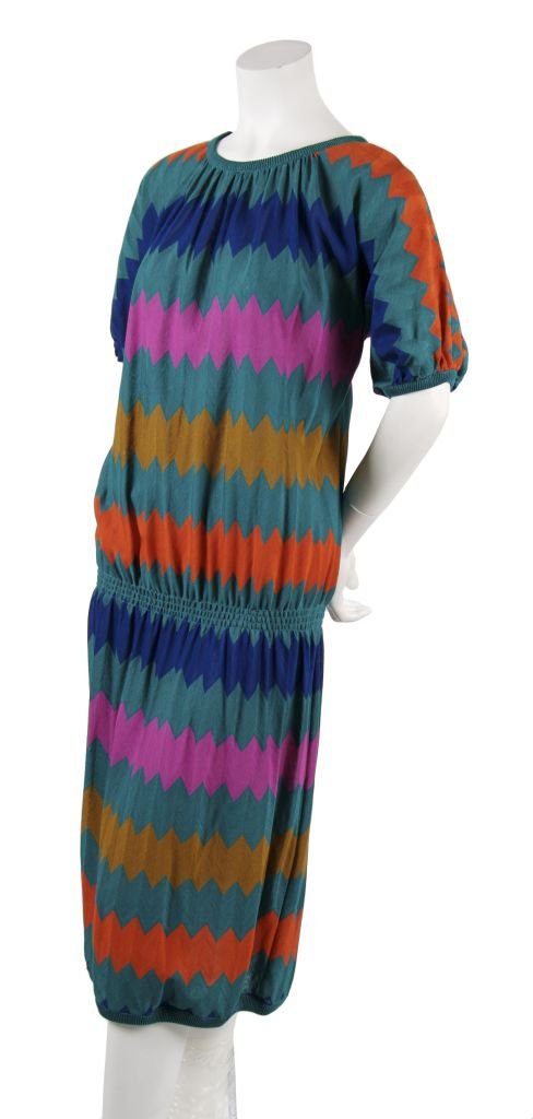A Missoni Colorblock Knit Dress, Size L.: A Missoni Colorblock Knit Dress, 1980s, in teal knit with multicolored zigzags, slight dolman sleeve, gathered at round neckline and low waist, knit binding at sleeves, neckline and hem. Labeled: Miss