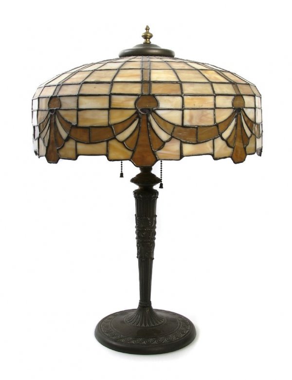 An American Leaded Glass Lamp, Diameter of shade 1: An American Leaded Glass Lamp, first half 20th century, the domed shade with swag border, raised on a cast metal baluster form base. Diameter of shade 16 1/2 inches, height overall 23 inches.