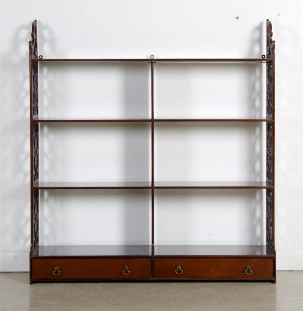 An American Hanging Mahogany Shelf, Kittinger, Hei: An American Hanging Mahogany Shelf, Kittinger, having pierced decorated sides of geometric decoration, with three shelves above one row of two rectangular drawers, having mark on interior of drawer. H