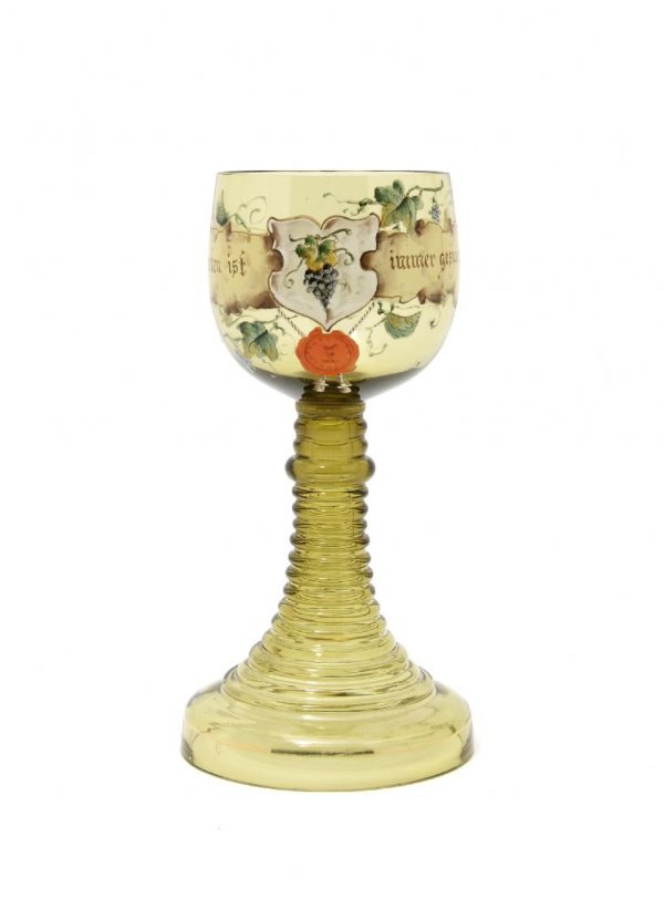 A German Glass Goblet, Height 8 3/4 inches.: A German Glass Goblet, the bowl enameled with grapevines and the phrase 'Trinken ist immer gesund,' raised on a stepped stem and base. Height 8 3/4 inches.