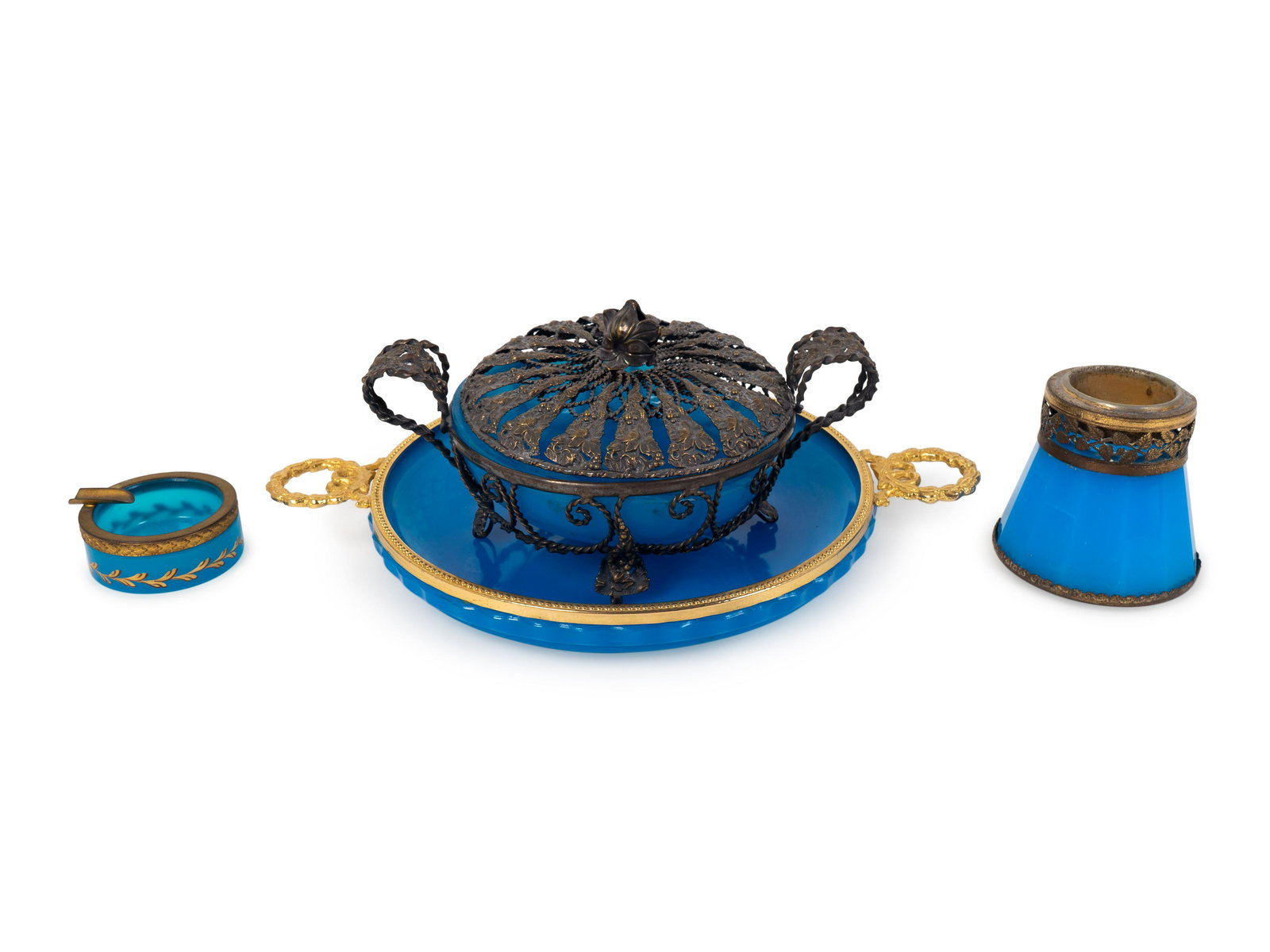 A Group of Four Metal Mounted Blue Opaline Glass: A Group of Four Metal Mounted Blue Opaline Glass Articles 19TH/20TH CENTURY comprising an ash receiver, a candle holder, a silvered metal mounted lidded candy dish, and a shallow bowl with cut glass b