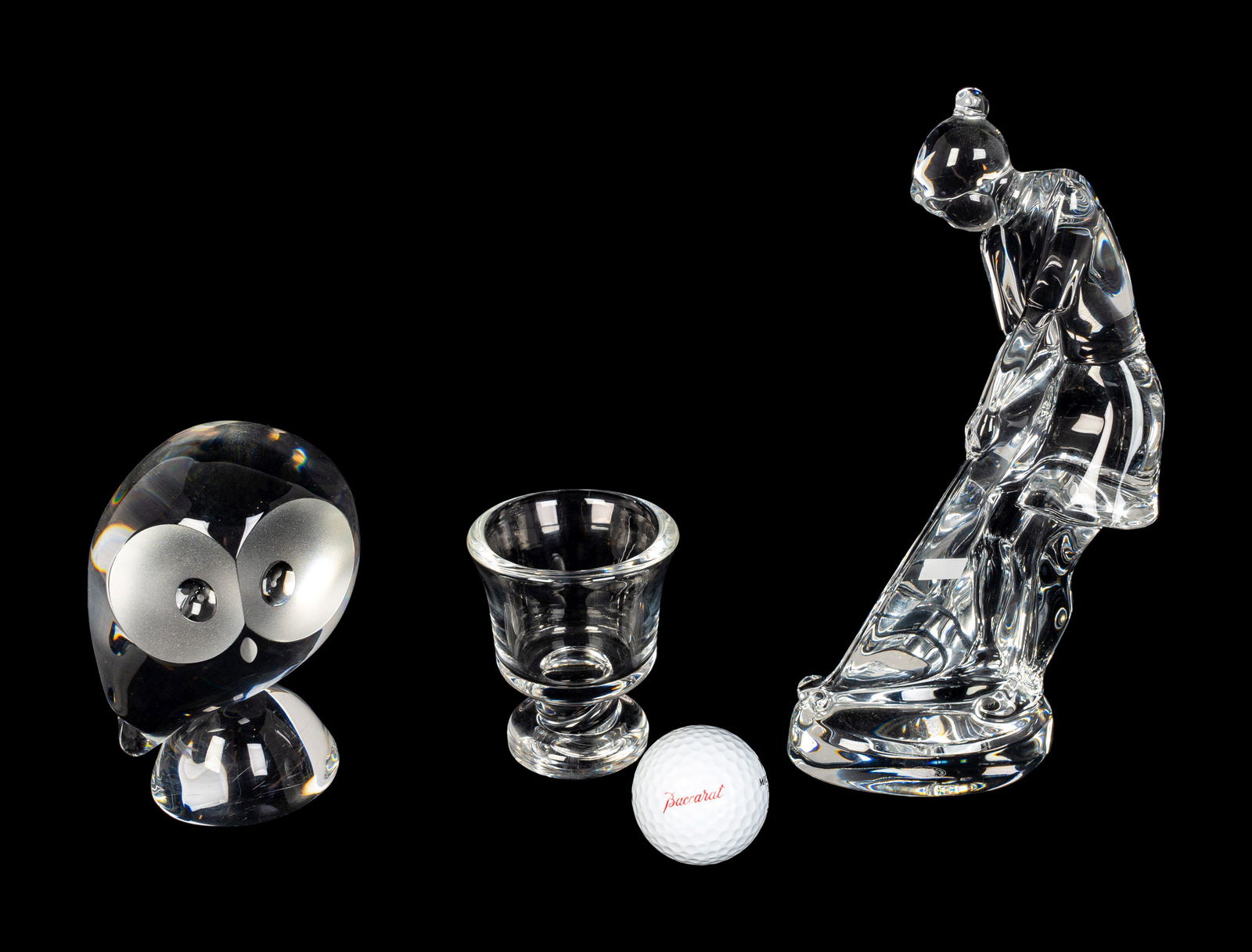 A Baccarat Figure of a Female Golfer, a Spaulding: A Baccarat Figure of a Female Golfer, a Spaulding Baccarat Golf Ball, a Steuben Toothpick Holder and a Steuben Owl Height of owl 5 inches; height of vase 8 1/2 inches. Property of a Boca Raton Private