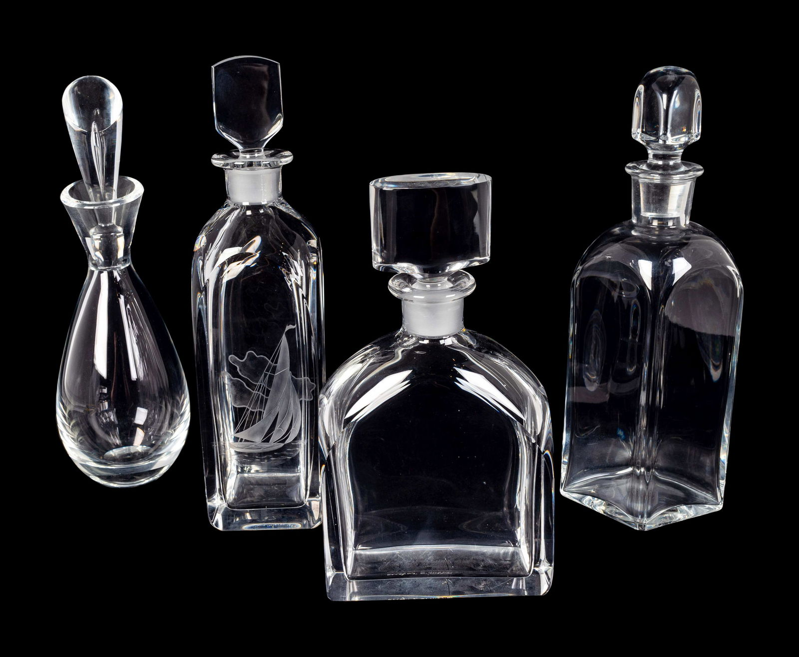 Four Glass Decanters Heights 8 1/2 to 9 1/4 inches.: Four Glass Decanters Comprising a Baccarat diamond-form decanter, a Steuben ovoid decanter, an Orrefors decanter, and a decanter etched with a sailboat and inscribed FN251b LK. Heights 8 1/2 to 9 1/4