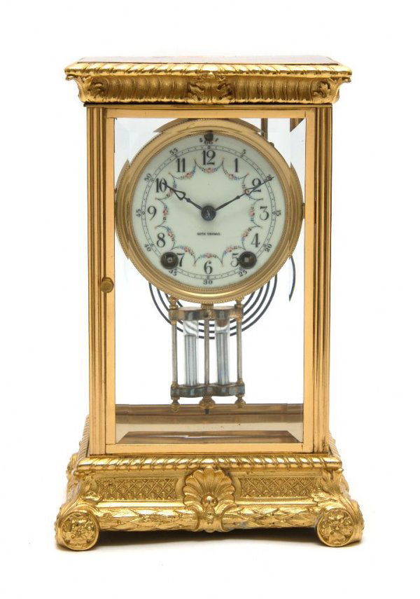 A Crystal Regulator Clock, Seth Thomas, Height 11 1/2 i: A Crystal Regulator Clock, Seth Thomas, the 3 1/2 inch porcelain dial with Arabic numerals and decorated with a floral garland, with mercury pendulum and key. Height 11 1/2 inches.