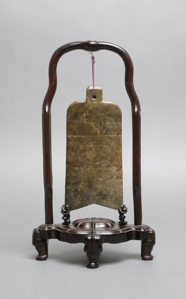 A Chinese Blade Form Hanging Jade Carving, Height : A Chinese Blade Form Hanging Jade Carving, in the style of the Zhou Dynasty, the stone brown and green in color, with three horizontal registers of decoration, the top two of masks with the bottom dep