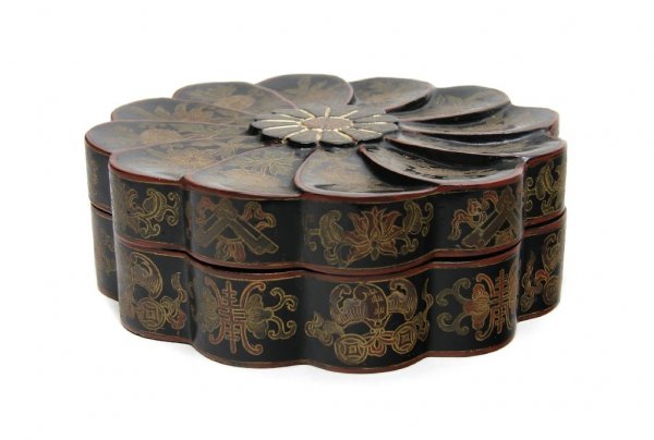 A Chinese Lacquer Lidded Box, Height 3 1/2 x width: A Chinese Lacquer Lidded Box, the floriform box having black reserve with incised and painted floral decoration throughout, the exterior sides decorated with Buddhist symbols. Height 3 1/2 x width 10 