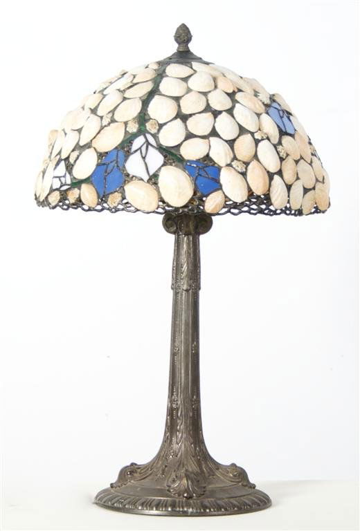 A Cast Metal Table Lamp, Height 25 inches.: A Cast Metal Table Lamp, having a shell and glass shade, the whole raised on a circular base. Height 25 inches.