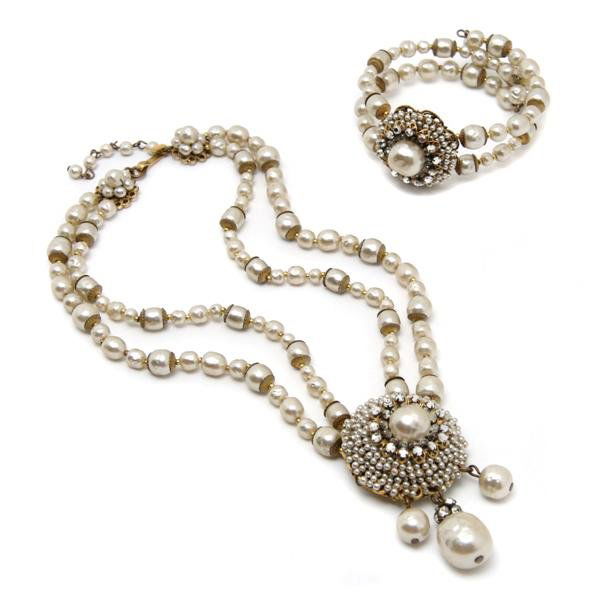 A Miriam Haskell Demi Parure,: A Miriam Haskell Demi Parure, 1950s, double stranded faux pearl necklace with faux seed pearl and rhinestone pendant, signature clasp. Together with a matching cuff bracelet. Stamped: Miriam Haskell.