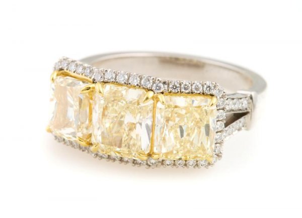 A Platinum and Fancy Yellow Diamond Ring, 6.50 dwts.: A Platinum and Fancy Yellow Diamond Ring, containing three large fancy yellow diamonds weighing approximately 4.55 carats total and several small round brilliant cut diamonds weighing approximately 0.