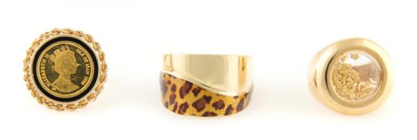 A Group of Three 14 Karat Yellow Gold Rings, 13.00 dwts: A Group of Three 14 Karat Yellow Gold Rings, the first with leopard print enamel, the second with loose gold flakes contained in glass, the third and one with a gold coin of Queen Elizabeth II. 13.00