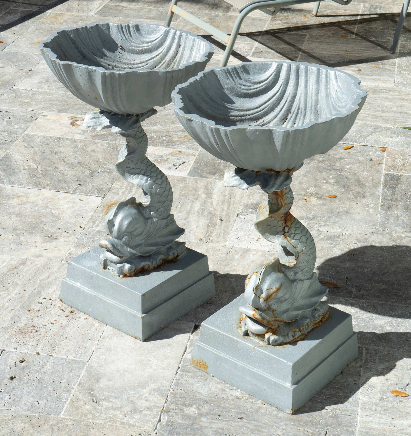 A Pair of Neoclassical Painted Iron Jardinieres Height: A Pair of Neoclassical Painted Iron Jardinieres with shell-form bowls supported by a dolphin, on a rectangular base. Being sold in situ. Height 26 x diameter 15 1/2 inches.