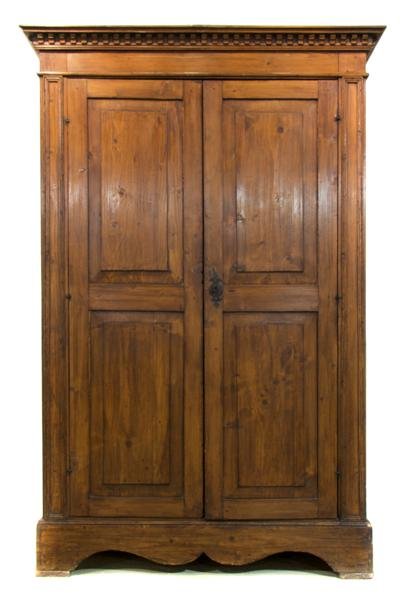 A Continental Fruitwood Armoire, Height 78 1/4 x w: A Continental Fruitwood Armoire, having a dentiled cornice over two paneled doors above a shaped skirt, raised on bracket feet. Height 78 1/4 x width 51 x depth 23 inches. Property from the Estates of