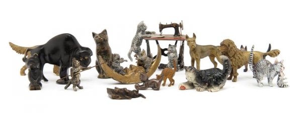 A Collection of Austrian Bronze Figures, Height of: A Collection of Austrian Bronze Figures, comprising two cats at a sewing machine, two cats on the moon, three dogs, eight additional cats, a bison and a bear cub. Height of tallest 2 1/4 inches. Prope