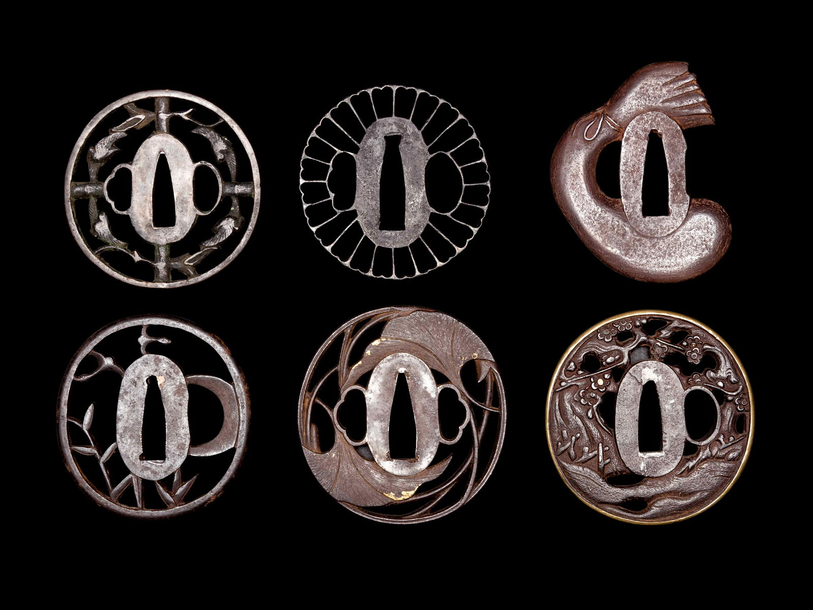 Six Cast Iron Tsuba: Six Cast Iron Tsuba 19TH CENTURY comprising five of sukashi type, the first depicting samurai figures underneath prunus branches, with gold inlays and a brass rim, the second showing ginko leaves with