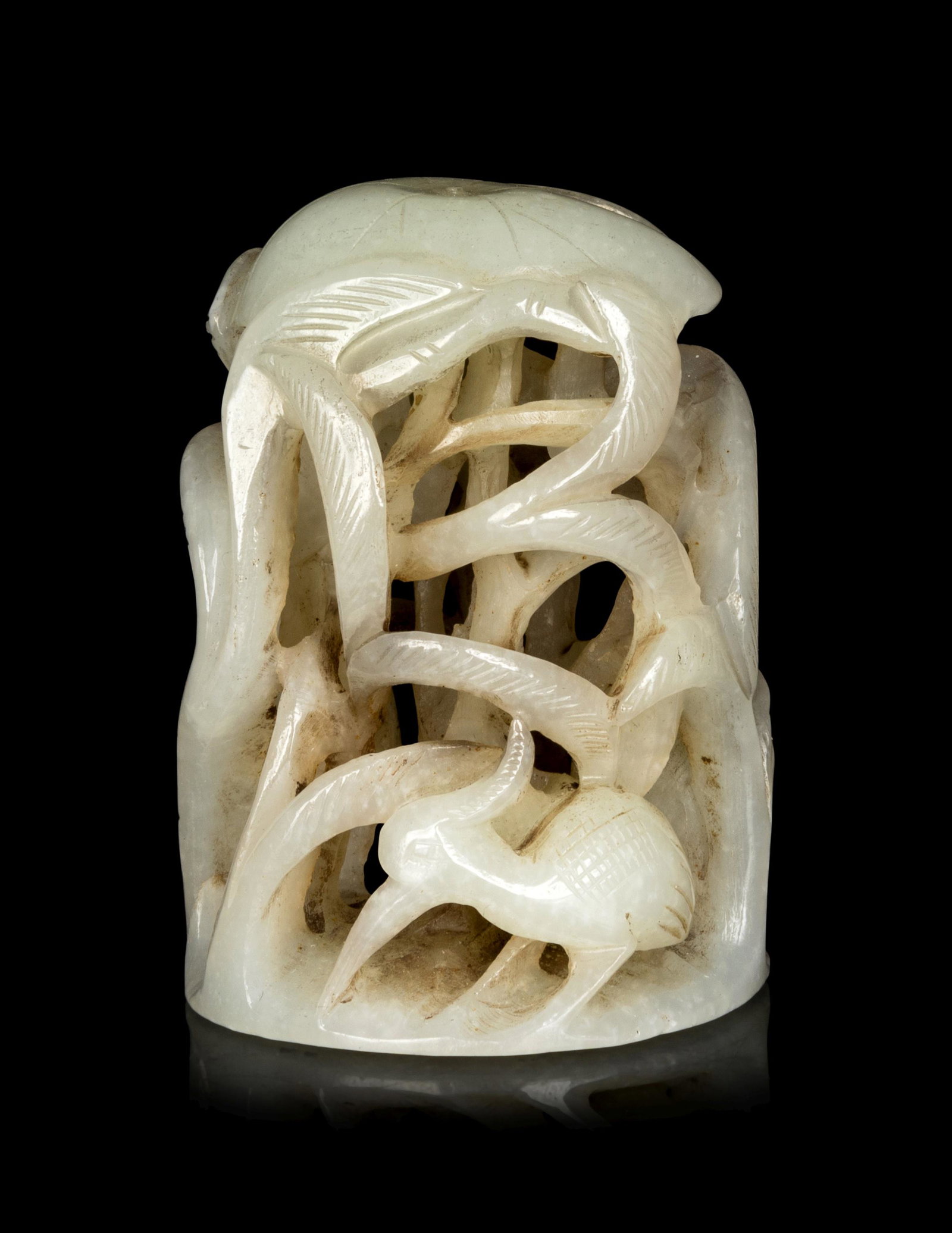 A Chinese Celadon Jade 'Egret and Lotus' Finial: A Chinese Celadon Jade 'Egret and Lotus' Finial of loosely cylindrical form, carved and reticulated with tall egrets amongst winding lotus stems. Height 2 1/2 in., 6.35 cm.