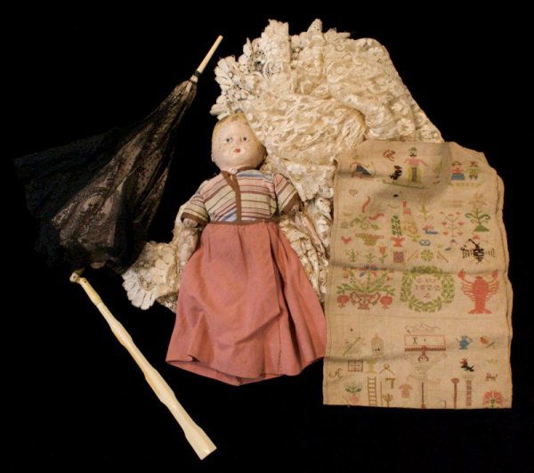 A Sampler Dated 1822, Height of first 26 x width 8: A Sampler Dated 1822, together with an assortment of handmade lace, parasoles, miscellaneous buttons, children's clothing and accessories. Height of first 26 x width 8 3/4 inches.
