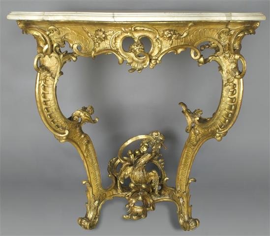 A Louis XV Giltwood Corner Table, Height 34 x widt: A Louis XV Giltwood Corner Table, having triangular white marble top with serpentine front above a pierce carved scrolling frieze with shell and foliate decoration, the legs joined by stretchers cente