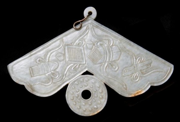 A Jade Chime Form Plaque, Width 7 inches.: A Jade Chime Form Plaque, the stone of gray and green in color, with relief carving of Buddhist emblems, with a bi in the lower register. Width 7 inches. Property of a Private Midwest Collector