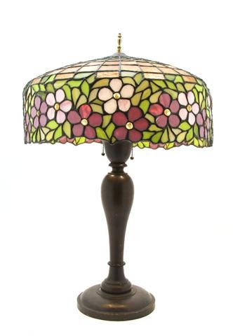 An American Leaded Glass Lamp, attributed to Hand: An American Leaded Glass Lamp, attributed to Handel, the domed shade with upper geometric pattern over the jeweled floral band, raised on a turned wood base. Diameter of shade 19 1/2 inches, height ov