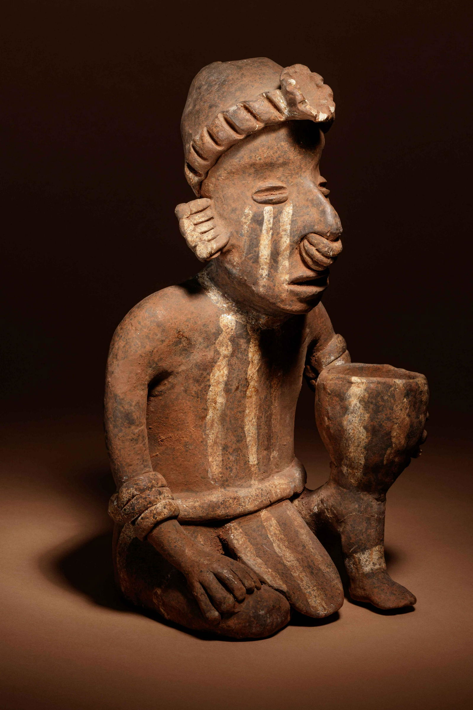 A Nayarit Terracotta Crouching Figure with Vessel (1 of 3)