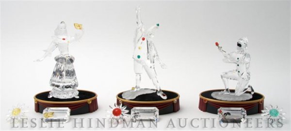 A Set of Three Swarovski Crystal Figurines, Height: A Set of Three Swarovski Crystal Figurines, from the Masquerade series, comprising 1990 Pierrot, 2000 Columbine, and 2001 Harlequin, together with stands, crystal name plaques and flowers, each with o