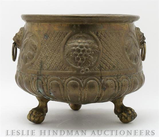 A Brass Jardiniere Height of first 13 inches.: A Brass Jardiniere having fruit panels and lion handles together with a wirework planter. Height of first 13 inches. Property from the Estate of Ernest Trova, St. Louis, Missouri