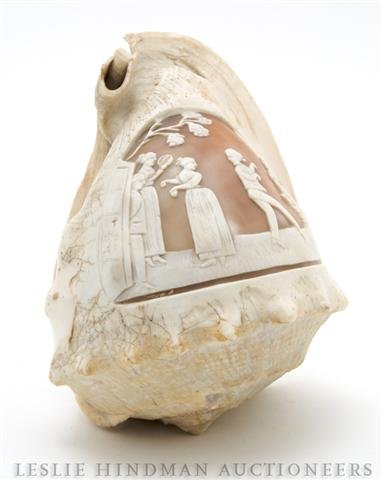 A Cameo Carved Shell, Length overall 5 3/4 inches.: A Cameo Carved Shell, depicting figures in an exterior. Length overall 5 3/4 inches. Property from the Private Collection of Candy Biederer, Des Plaines, Illinois