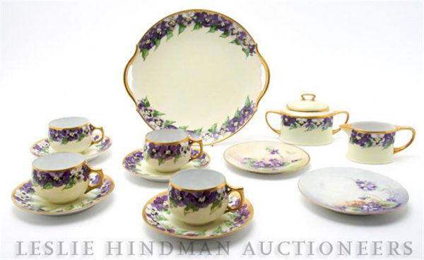 An Assembled Porcelain Luncheon Set, Diameter of p: An Assembled Porcelain Luncheon Set, comprising 12 dessert plates, creamer, covered sugar, 12 cups and 12 saucers, having pansy boarders and gold trim, together with two associated plates. Diameter of
