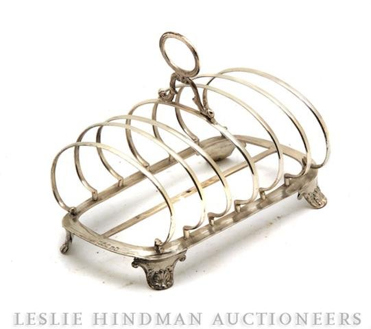An English Regency Silver Toast Rack, Height 5 1/2: An English Regency Silver Toast Rack, Newcastle, 1817, raised on feet repousse with shells, maker's mark IW. Height 5 1/2 inches.