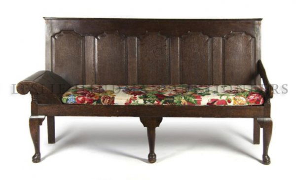 An English Oak Settee, Height 41 x width 76 x depth 28 : An English Oak Settee, 19th century, having a rectangular paneled back above one scrolled arm rest and one straight arm, having wood slat seat with upholstered cushion, raised on cabriole legs at fron