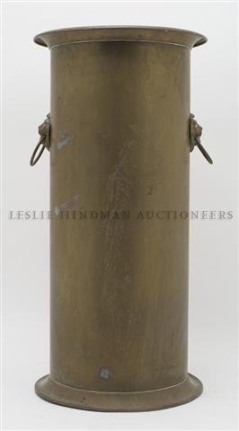 A Brass Umbrella Stand, Height 21 1/2 inches.: A Brass Umbrella Stand, of cylindrical form, further mounted with lion masks and ring handles. Height 21 1/2 inches.