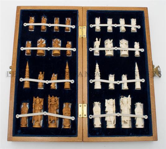 A Carved Ivory Chess Set, Height of tallest 3 1/2 inche: A Carved Ivory Chess Set, half of the figures having red dye, the other natural tone contained in a wood box with game board; 32 items total. Height of tallest 3 1/2 inches.