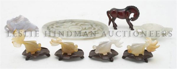 A Carved Jade Cup and Saucer, Width of first overall 6 : A Carved Jade Cup and Saucer, comprising a jade cup and fitted tray, four agate koi and an agate dish, together with two compressed amber horses. Width of first overall 6 1/4 inches. Property from the