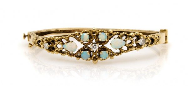 A 14 Karat Yellow Gold, Opal and Diamond Bangle Bracele: A 14 Karat Yellow Gold, Opal and Diamond Bangle Bracelet, containing six pear shape and round cabochon opals weighing approximately 1.00 carat total, three round brilliant diamonds weighing approximat