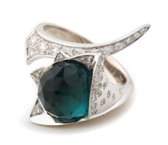 An 18 Karat White Gold, Diamond and Green Tourmaline Ri: An 18 Karat White Gold, Diamond and Green Tourmaline Ring, Stephen Webster, containing one faceted cabochon cut green tourmaline and numerous round brilliant cut diamonds weighing approximately 0.50 c