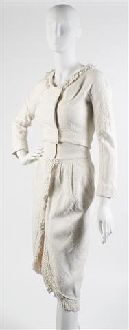 A Mr. John Ivory Embossed Cotton Trapunto Suit,: A Mr. John Ivory Embossed Cotton Trapunto Suit, 1960s, jacket with fringe collar and snap closure, together with a matching narrow skirt with fringe. Labeled: Mr. John Sophisticate New York Paris.