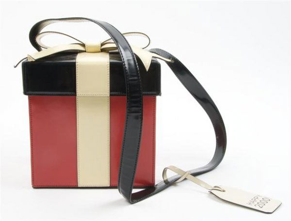 A Moschino Red Black and White Leather 'Present' Purse,: A Moschino Red Black and White Leather 'Present' Purse, with a long black leather shoulder strap. Stamped: Moschino. 6 x 6 x 6 inches.