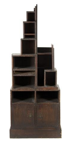 An American Painted Skyscraper Bookcase, After Paul Fra: An American Painted Skyscraper Bookcase, After Paul Frankl, in two parts, the superstructure of asymmetrical form with various shelves, the base with two cabinet doors. Height 74 inches.
