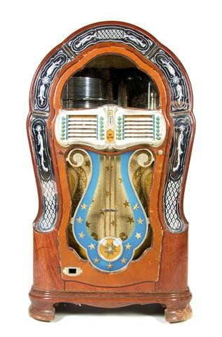 A Wurlitzer Juke Box, Model 1080, Height 58 1/4 x width: A Wurlitzer Juke Box, Model 1080, 1947, serial number 1947844, 78 rpm records, 24 selections, having mirrored panels on front, designed by Paul Fuller, together with a box of records, including Frank